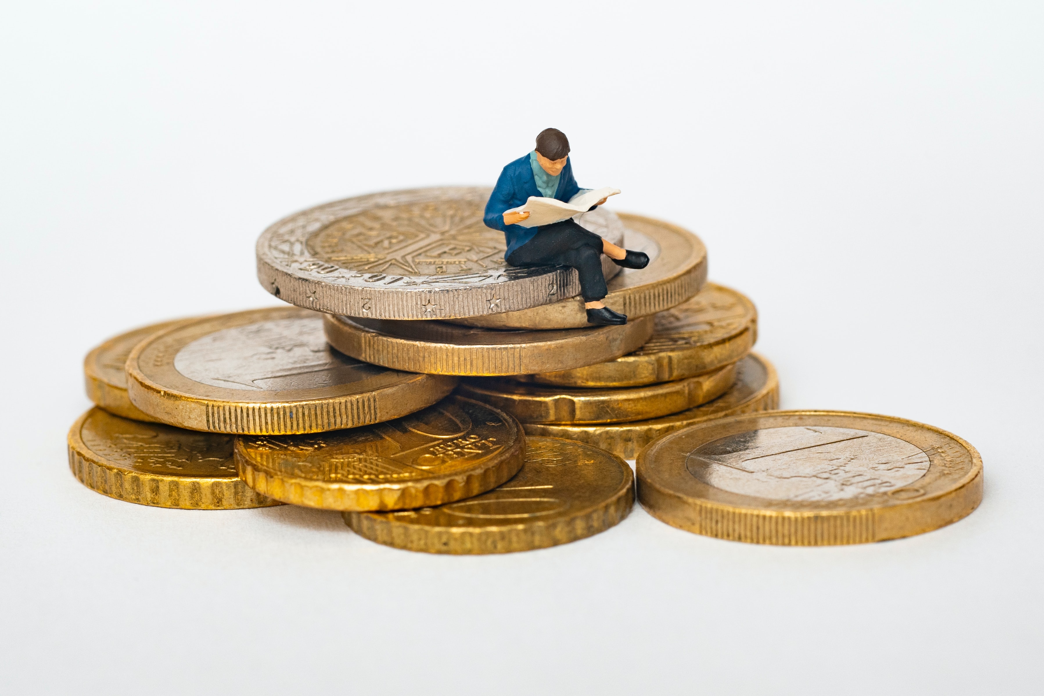 Figure of Man Reading Book Sitting on Coins